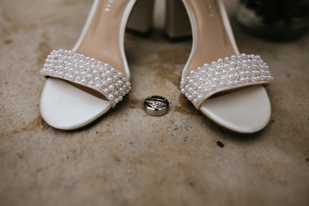 bride shoes and rings on rock