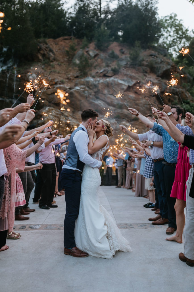 Bride and groom kissing during sparkler exit