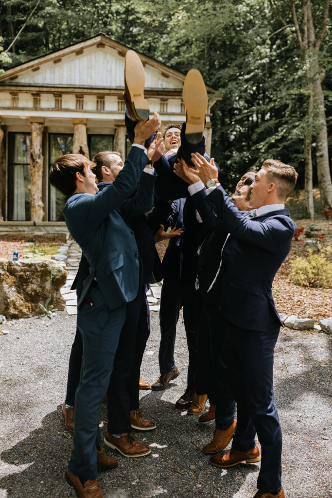 groomsmen throwing groom into air 