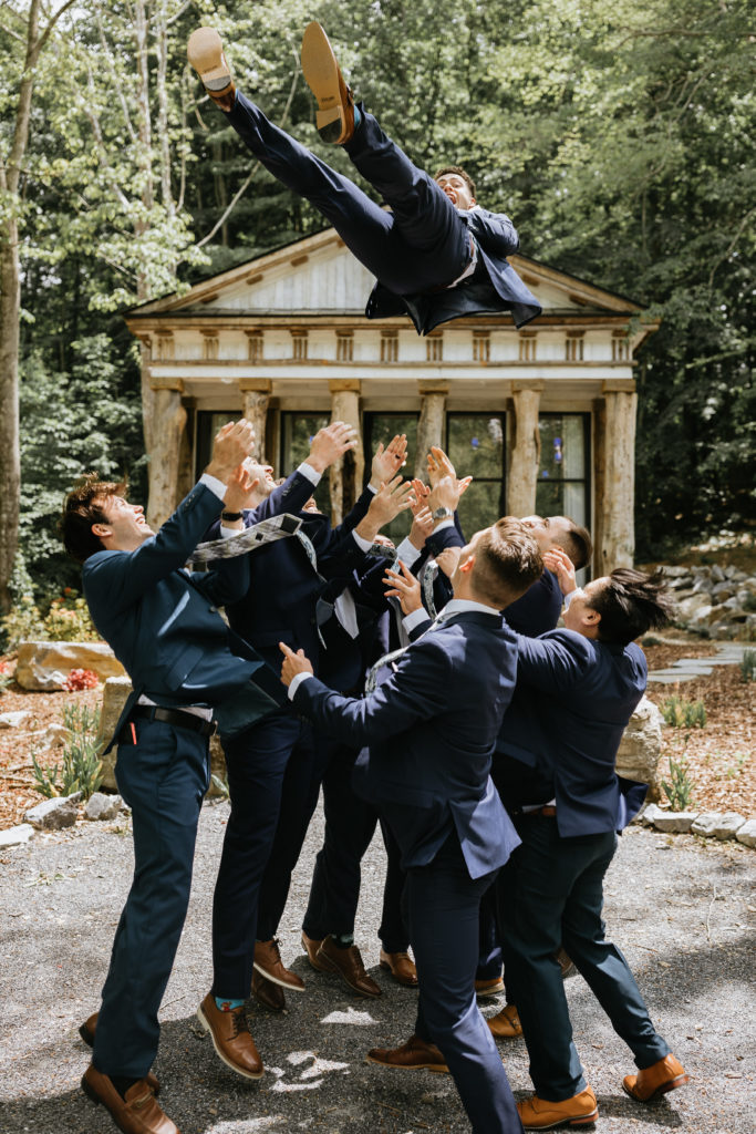 groomsmen throwing groom into air 
