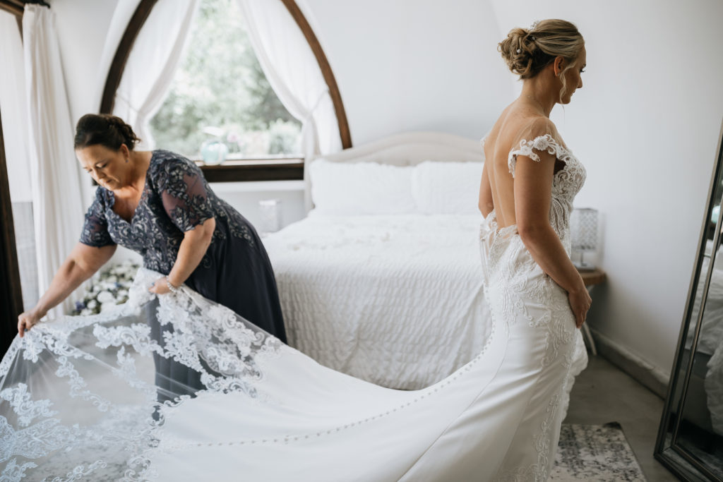 mom helping bride with dress