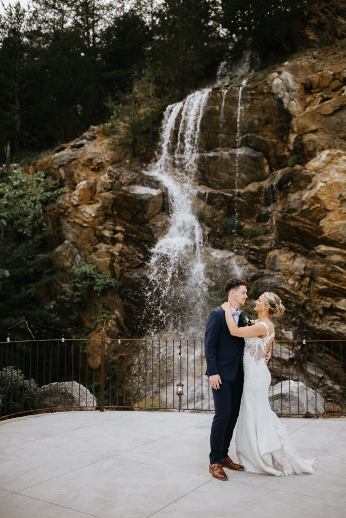 Bride and groom in front of waterfall 