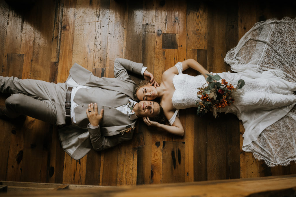 The Millstone bride and groom laying on ground beside stairs
