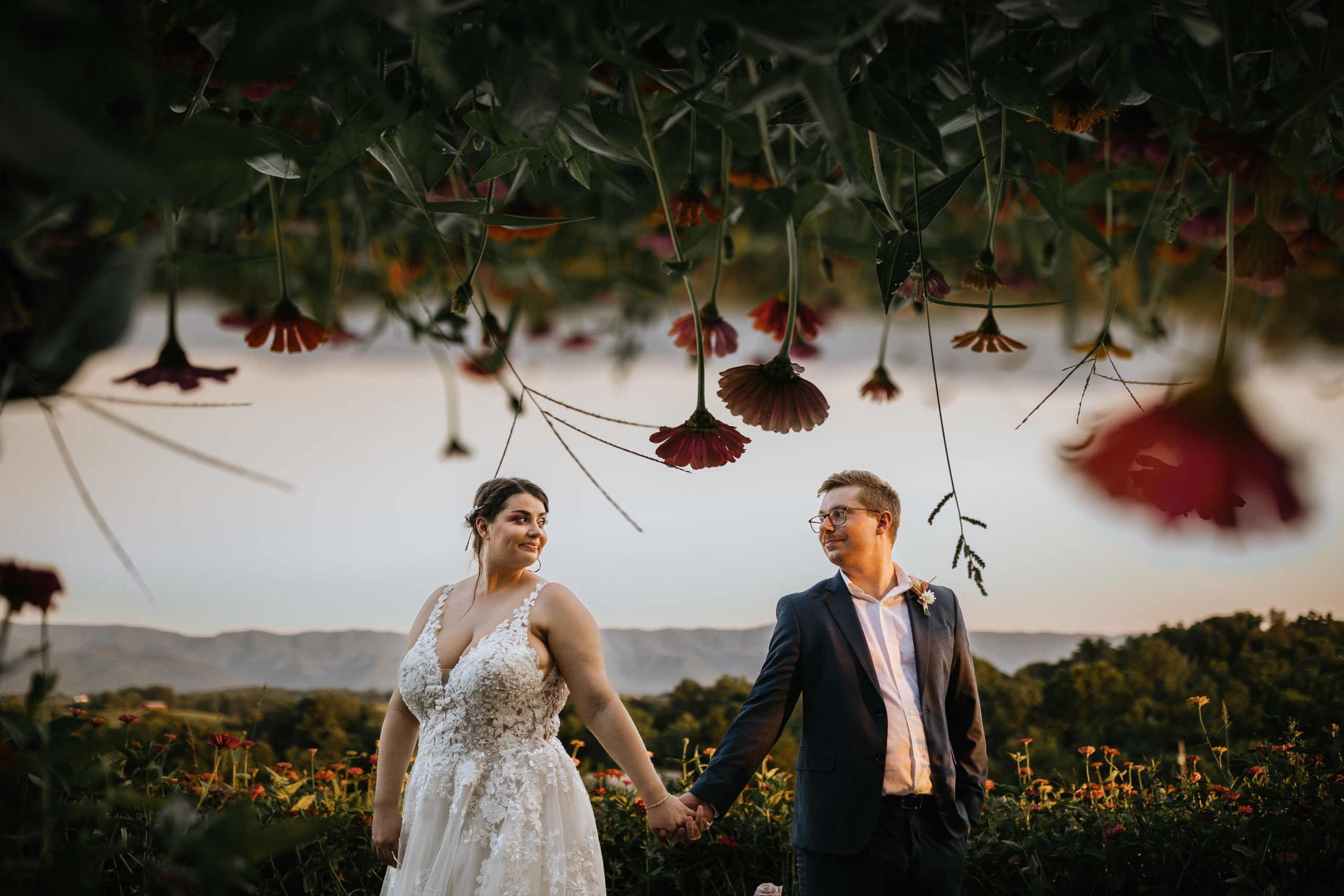 Creative photo of bride and groom with zinnia wildflowers at the top