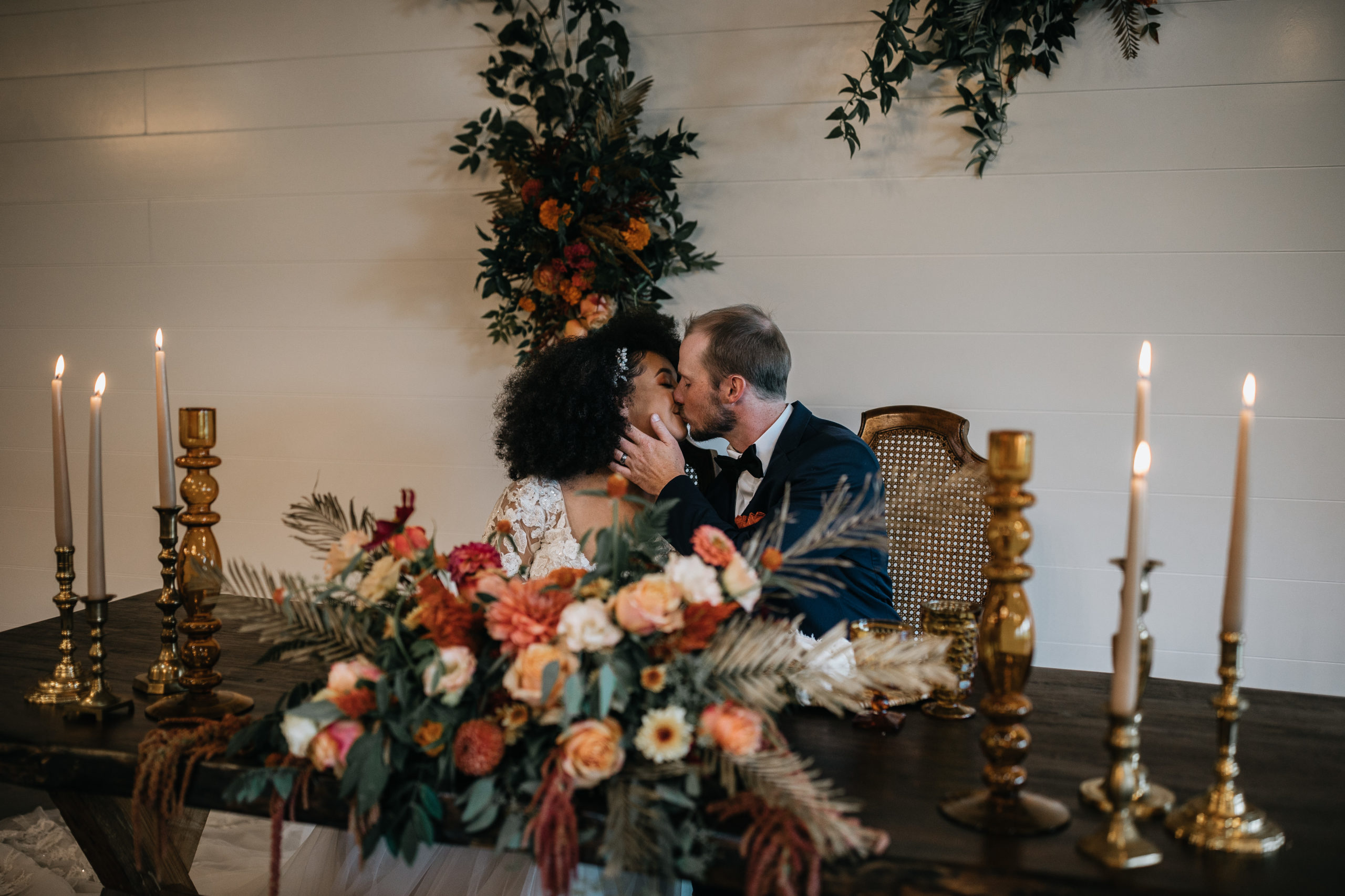 bride and groom kissing at their reception table at greenwood oaks