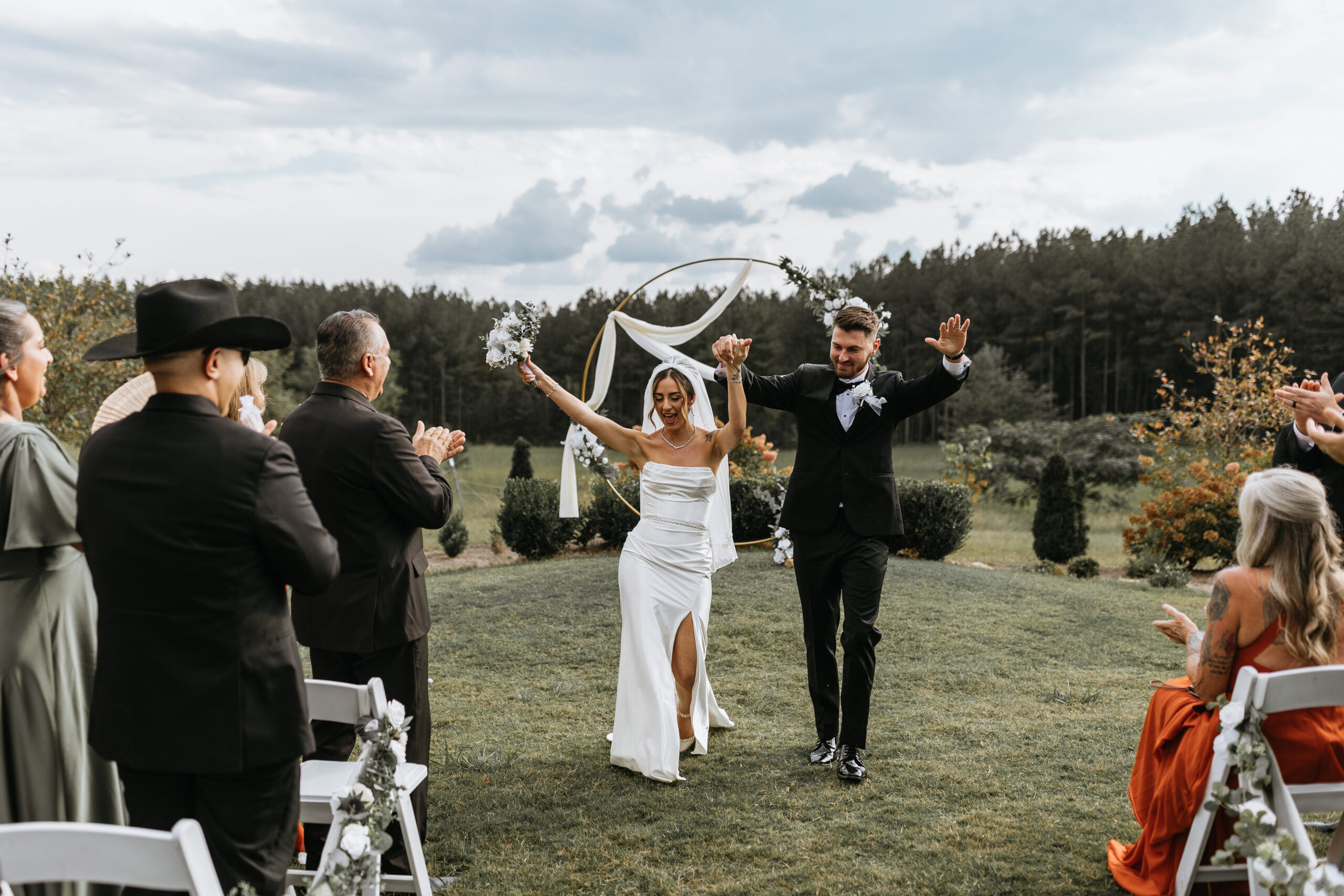 bride and groom dance down aisle and crowd claps after getting married