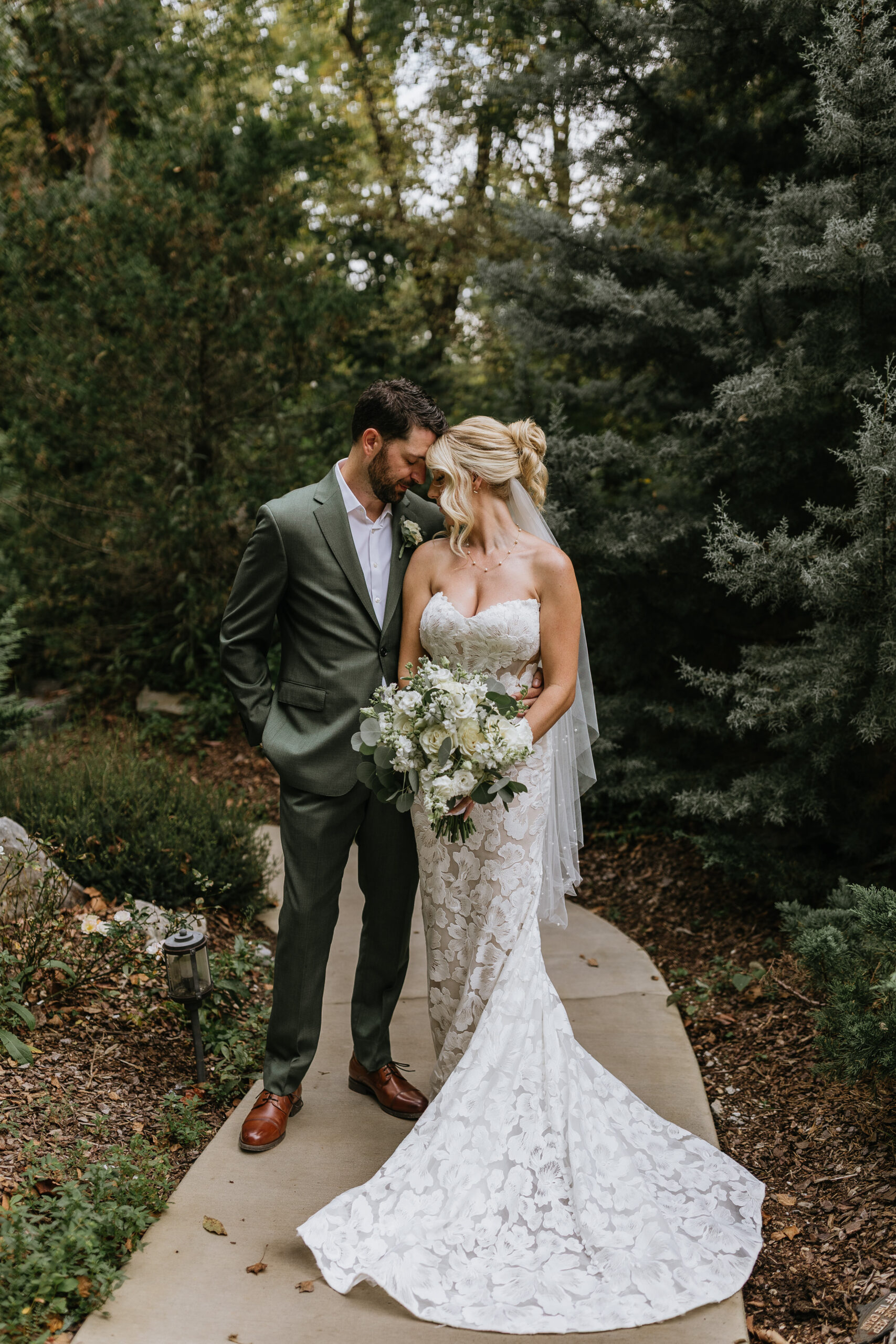 bride and groom stand as their foreheads rest together during their waterstone wedding